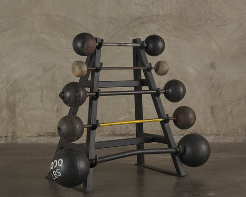 COLLECTION OF ANTIQUE BARBELLS ON STEEL MOUNT